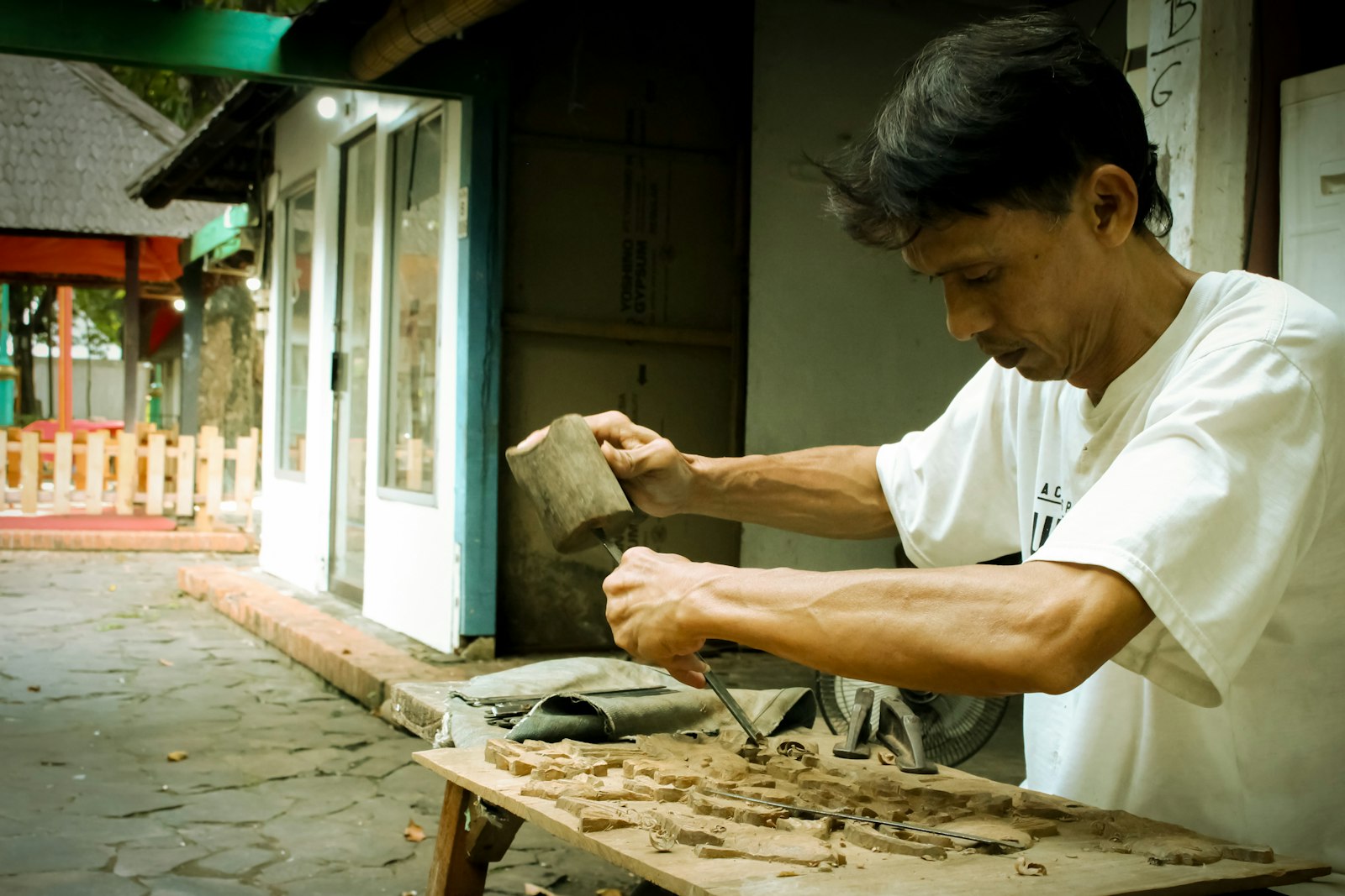 Indonesian craftsman working on a piece of wood